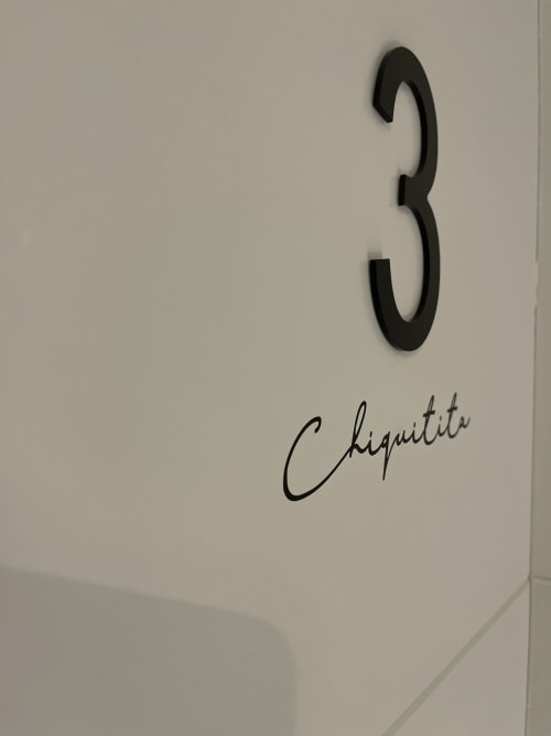 Decoración de pared con número 3 negro y texto manuscrito 'Chiquiti' en habitación del Hotel Boutique Mamma Mia Tossa, Tossa del Mar