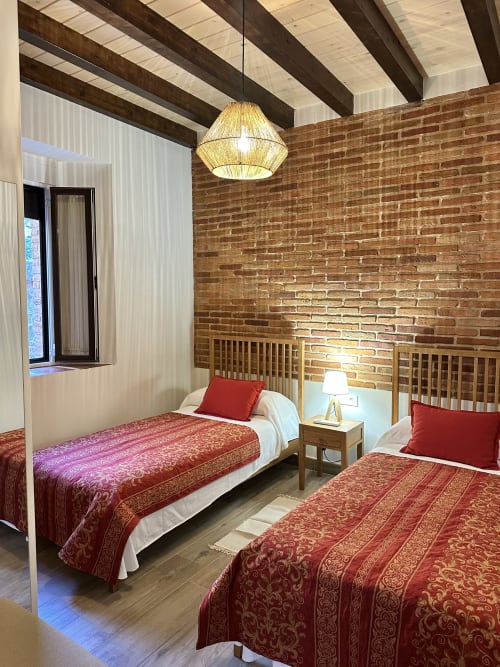 Habitación doble con colchas rojas estampadas en El Escondite De Pedro Malillo, Candeleda
