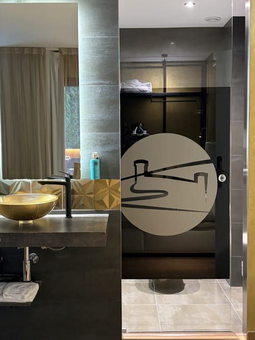 Baño moderno del Hotel Boutique Mamma Mia Tossa con fixtures negros, espejo con detalles dorados y diseño contemporáneo