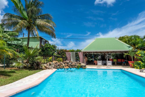 Gites villa Bagatelle pool with palm trees and green-roofed cabana in Sainte-Rose, Guadeloupe