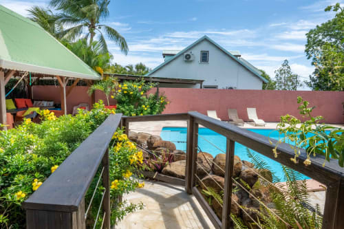 Gites villa Bagatelle pool area in Sainte-Rose with lounge chairs, tropical plants, and wooden deck overlooking swimming pool