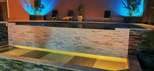 Réception moderne avec façade en briques et éclairage bleu ambiant à la Résidence B&L Lagon, boutique hôtel en Martinique