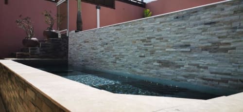 Piscine à débordement moderne à la Résidence B&L Lagon avec mur en pierre et architecture en terre cuite