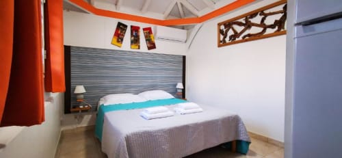 Chambre accueillante à la bungalow Résidence B&L Lagon avec accents turquoise et vue sur jardin en Martinique