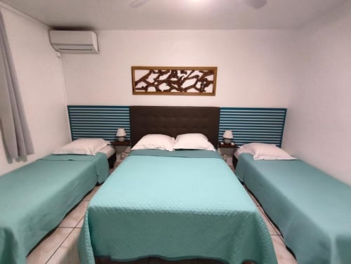 Lits triples aux draps turquoise dans l'appartement Alisée à la Résidence B&L Lagon, Sainte-Luce