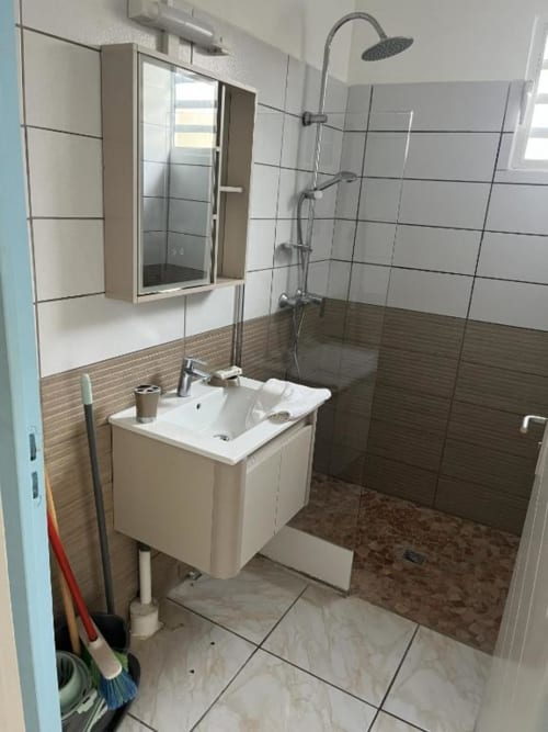 Salle de bain moderne avec douche à l'italienne, vasque et sol carrelé à la Résidence B&L Lagon à Sainte-Luce
