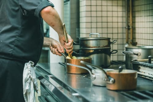 Chef preparing food in kitchen at Au Bon Gîte, a bed and breakfast in Senones, France