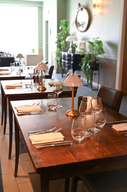 Salle à manger élégante de la Maison d'hôtes Au Bon Gîte à Senones avec tables en bois, couverts et luminaires en cuivre