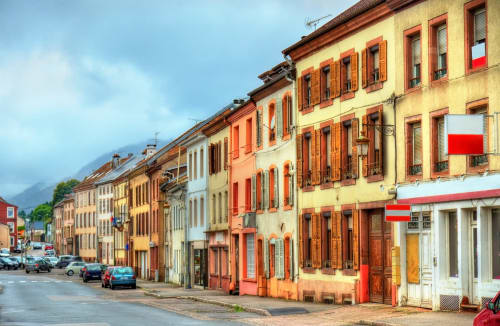 Bâtiments historiques colorés dans une rue de Senones, France, accueillant le gîte Au Bon Gîte