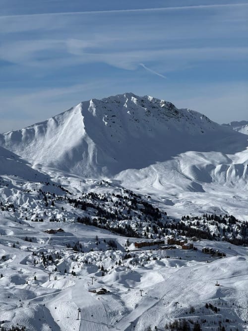 Pics alpins enneigés et pistes de ski à L'Alp'In, La Plagne Tarentaise, avec remontées mécaniques et refuge de montagne