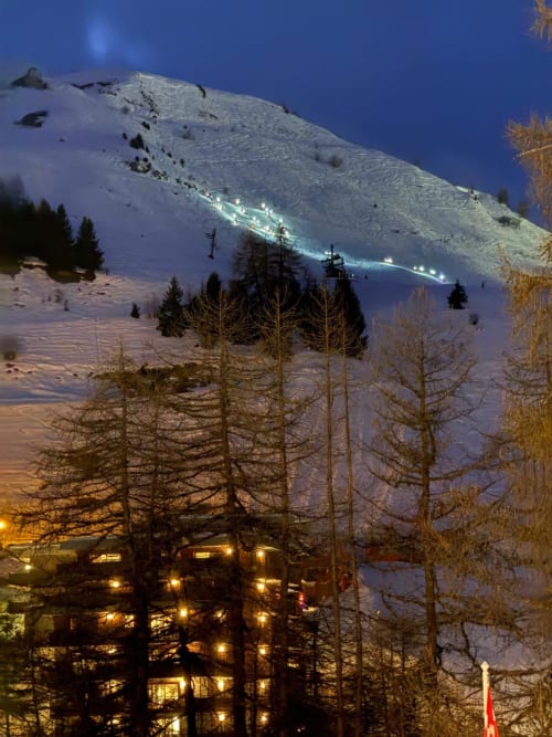 Vue nocturne de L'Alp'In avec pistes de ski et mélèzes à La Plagne, Alpes françaises