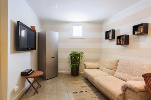 Camera doppia Marilù BnB Palermo con arredi beige, TV, frigorifero, divano e pareti a righe
