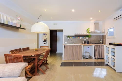 Cucina e zona pranzo open-plan in Marilù BnB, Palermo, con tavolo in legno, mobili bianchi e comfort moderni