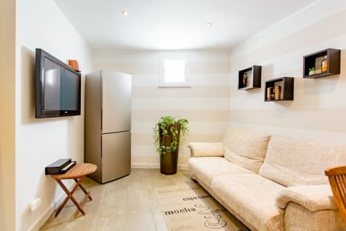 Camera doppia Marilù BnB a Palermo con divano crema, TV, frigo e vista dalla finestra