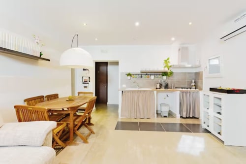 Cucina moderna a pianta aperta e zona pranzo della Marilù B&B di Palermo con tavolo in legno, lampada sospesa bianca e completa