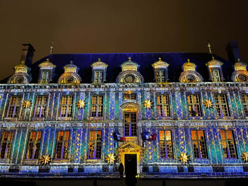 Façade illuminée de l'hôtel Maunoury Citybreak à Chartres avec architecture Art Déco bleue et or ornementale de nuit