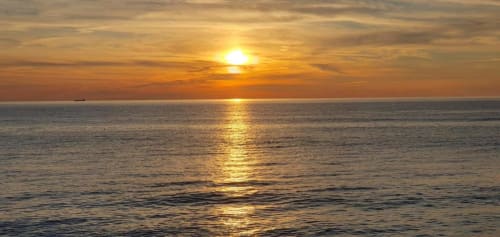 Alba dorata sulle tranquille acque dell'oceano presso la Mãe Maria House a Vila Chã, Portogallo