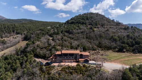 Hotel Fonsispa nestled in forested hills near Renanué, Spain with terracotta roof and surrounding woodland landscape