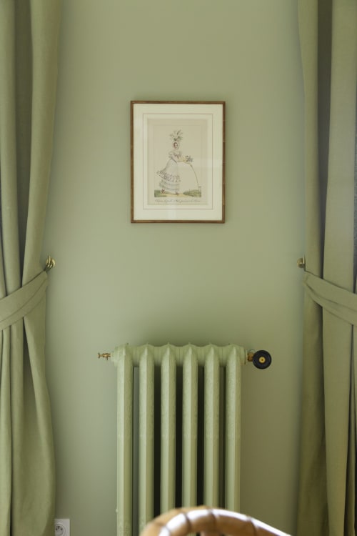 Chambre aux murs vert pâle avec estampe botanique vintage, radiateur crème et rideaux assortis à l'appartement studio Gare Godillot