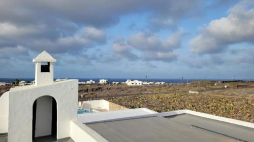 Villa blanca con azotea y vistas al océano en Mala, Lanzarote, terraza y paisaje volcánico