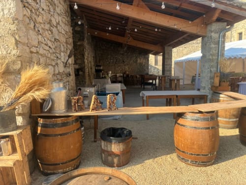 Espace événementiel rustique au Domaine Maison Girardon avec tables en tonneaux de vin et architecture en pierre à La Roche sur Grane