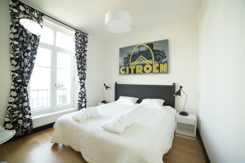 Chambre lumineuse du Studio 302 à la Gare Godillot B&B, Saint-Ouen-sur-Seine, avec tête de lit noire, literie blanche et Citroën vintage
