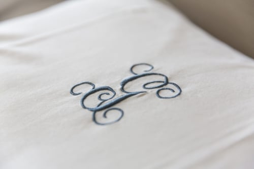 Monogramme brodé sur lin blanc à la boutique bed and breakfast Gare Godillot à Saint-Ouen-sur-Seine
