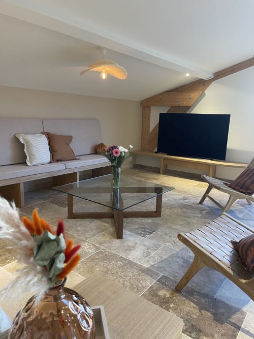 Spacieux séjour du Domaine Maison Girardon avec poutres en bois, table basse en verre et sièges confortables à La Roche sur