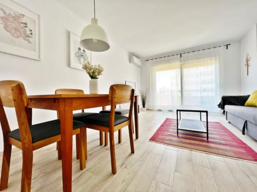 Moderno apartamento frente al mar en Fuengirola con zona de comedor, muebles de madera y sala luminosa