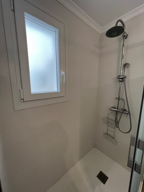 Baño moderno con ducha tipo lluvia y cestas de pared en apartamento frente al mar, Fuengirola