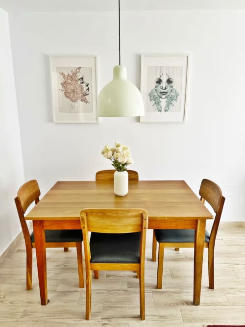 Comedor moderno con mesa de madera, sillas, lámpara colgante y arte botánico en apartamento frente al mar en Fuengirola