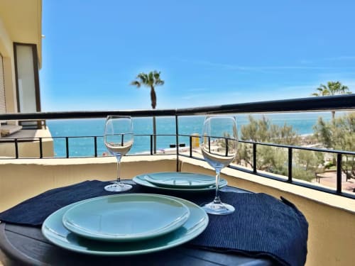 Balcón de apartamento frente al mar en Fuengirola con elegante mesa servida, copas de vino y vista al Mar Mediterráneo