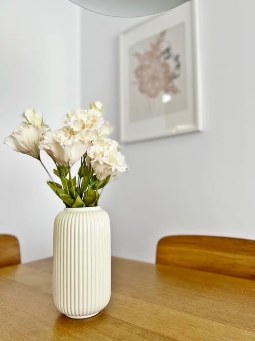 Claveles blancos en jarrón acanalado sobre mesa de madera, decoración de apartamento con vistas a la playa de Fuengirola