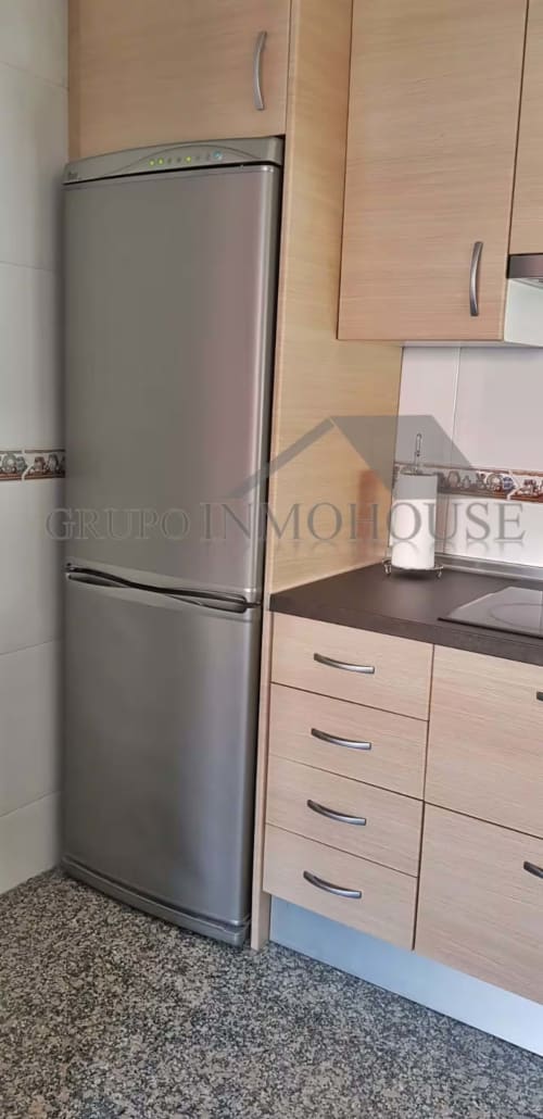 Cocina moderna con refrigerador de acero inoxidable y muebles de madera en el apartamento Grupo Inmo House, Fuengirola