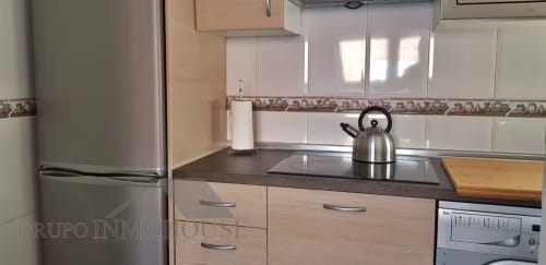 Cocina moderna en apartamento Grupo Inmo House de Fuengirola con electrodomésticos de acero inoxidable y gabinetes de madera clara