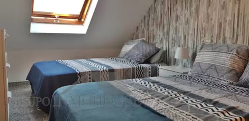 Luminosa habitación abuhardillada en Grupo Inmo House, Fuengirola, con camas individuales, claraboya y ropa de cama moderna a rayas