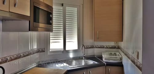 Cocina moderna en apartamento Ático del sol, Fuengirola, con electrodomésticos de acero inoxidable y luz natural