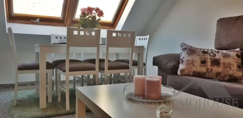 Luminoso salón de apartamento ático en Fuengirola con tragaluz, sillas de comedor, sofá y decoración con velas