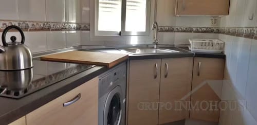 Cocina moderna con electrodomésticos de acero inoxidable, encimeras de madera y lavadora en el ático Ático del sol, Fuengirola