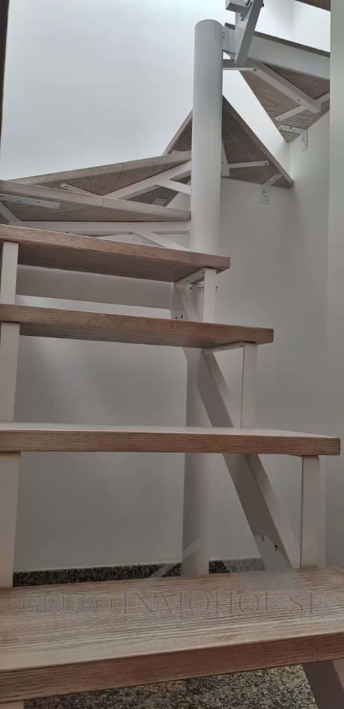 Escalera de caracol moderna con peldaños de madera y barandillas blancas en el Ático del sol, Fuengirola