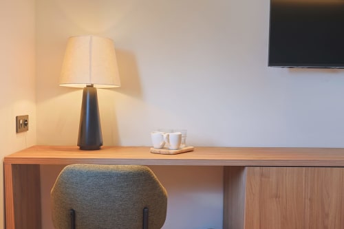 Recepción moderna del Hotel Fonsispa con lámpara, tazas y silla en Renanué