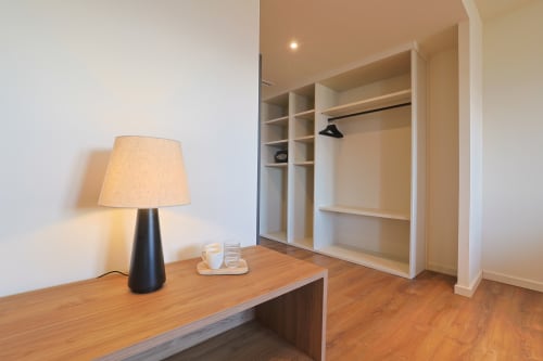 Área moderna de armario y escritorio del Hotel Fonsispa en Renanué con estanterías integradas y piso de madera