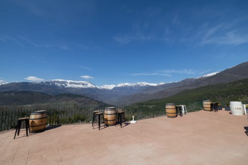 Asientos de barril de vino con vistas nevadas de la montaña en la terraza del Hotel Fonsispa en Renanué