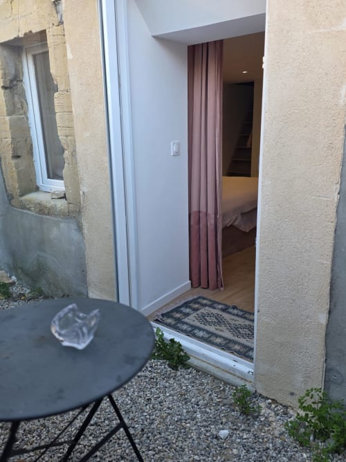 Entrée de la chambre La Petite Rose à la Villa Kahlo, Colleville-sur-Mer, avec table de patio et accès à la chambre