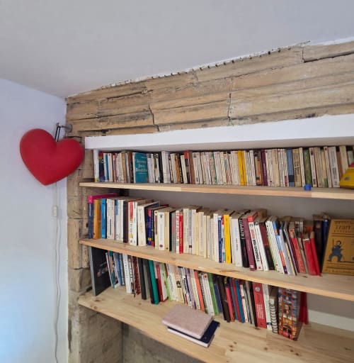 Étagère en bois avec des livres dans la chambre La Petite Rose à Villa Kahlo, Colleville sur Mer, ornée d'une décoration cœur rouge