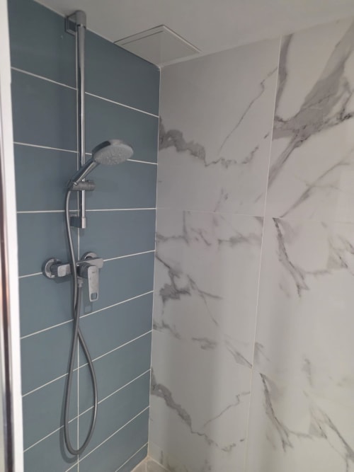 Salle de bain moderne avec carrelage bleu et pomme de douche effet pluie à Villa Kahlo, Colleville-sur-Mer