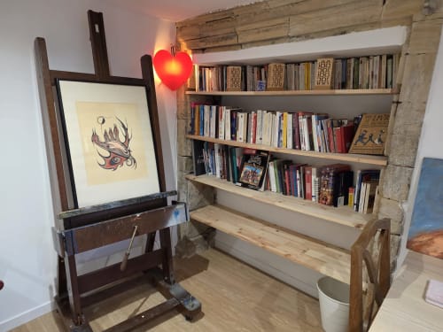 La chambre La Petite Rose à la Villa Kahlo Omaha Beach propose des étagères en bois, un chevalet avec des œuvres d'art et un coin lecture cosy