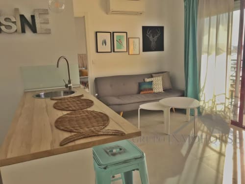 Moderno apartamento frente al mar en Fuengirola con cocina abierta, sofá gris y vistas a la ciudad