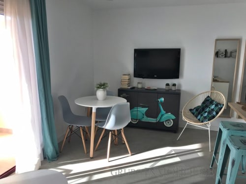 Apartamento moderno en Fuengirola con mesa de comedor, televisión, patinete turquesa decorativo y vistas al mar cerca de la playa