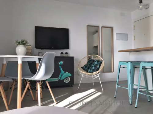 Moderno espacio de vida en apartamento de Fuengirola con escritorio, televisor y detalles en turquesa cerca del mar